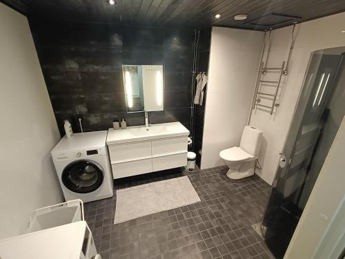 a bathroom with a sink and a washing machine at Big 88m2 apartment in the center in Rovaniemi