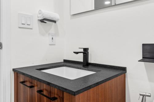 a bathroom sink with a black counter top at Downtown Luxury 1BR Coal Harbour in Vancouver