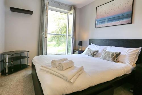 a bedroom with a large white bed with towels on it at Luxurious Townhouse In Central Manchester in Manchester