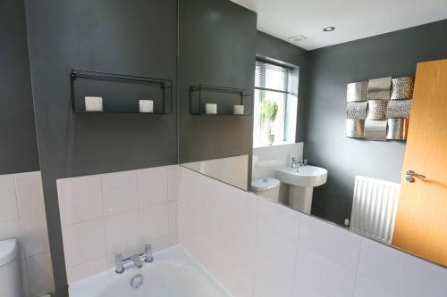 a bathroom with a white tub and a sink at Luxurious Townhouse In Central Manchester in Manchester