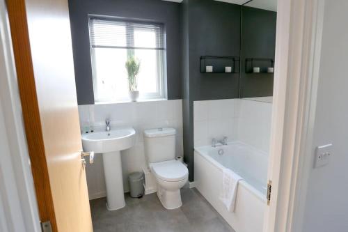 a bathroom with a toilet and a sink and a tub at Luxurious Townhouse In Central Manchester in Manchester