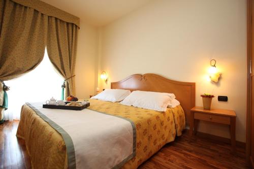 a bedroom with a large bed with a large window at Hotel Camoretti in Almenno San Bartolomeo