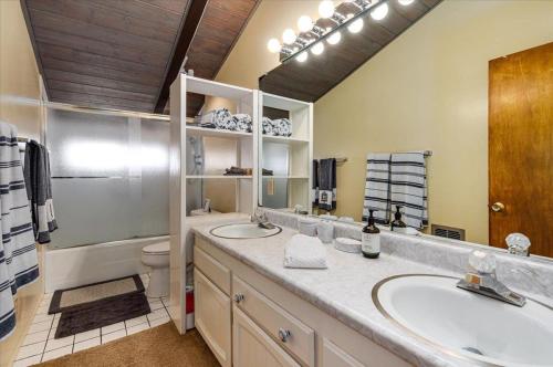een badkamer met 2 wastafels, een toilet en een spiegel bij Charming Farmhouse Amongst The Vines in Healdsburg