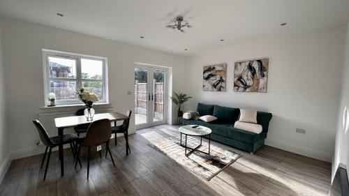 a living room with a green couch and a table at Newbuild, 3 Bedroom house with free parking in Aldershot