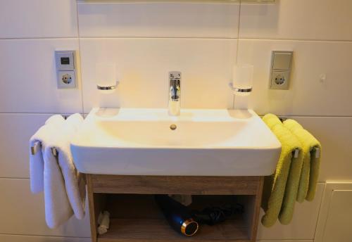 a white sink in a bathroom with towels at Gästehaus Sonner in Dietmannsried