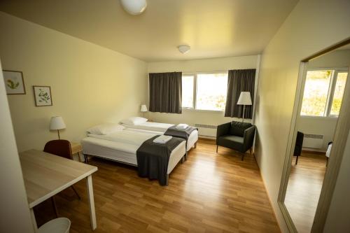 a bedroom with a bed and a desk and a chair at Fljótsdalsgrund in Valþjófsstaður