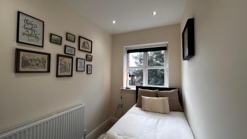 a small room with a bed with a window at Newbuild, 3 Bedroom house with free parking in Aldershot
