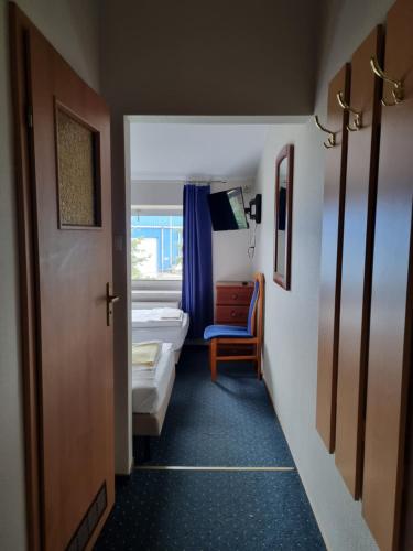 a small room with a bedroom with a bed and a window at Zajazd Bazylia in Ozorków