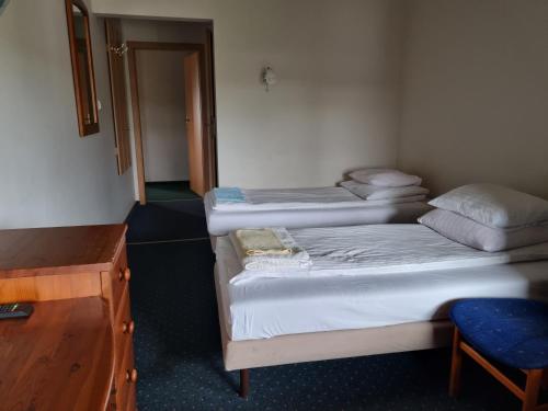 a room with three beds in a room with a desk at Zajazd Bazylia in Ozorków