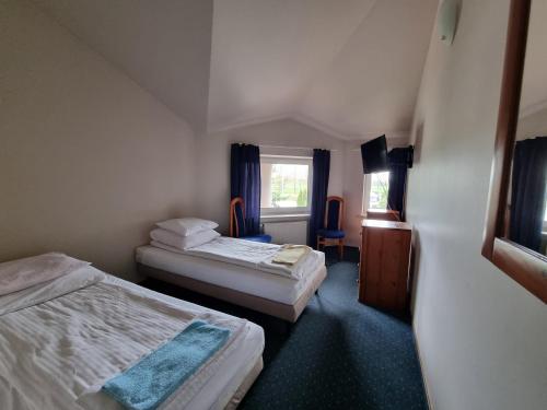 mały pokój z 2 łóżkami i oknem w obiekcie Zajazd Bazylia w mieście Ozorków