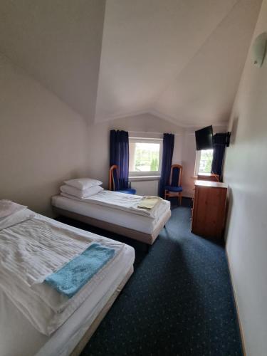a hotel room with two beds and a window at Zajazd Bazylia in Ozorków