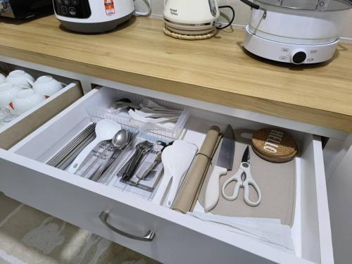 a drawer in a kitchen with utensils at The Seashore House, The Shore Kota Kinabalu in Kota Kinabalu