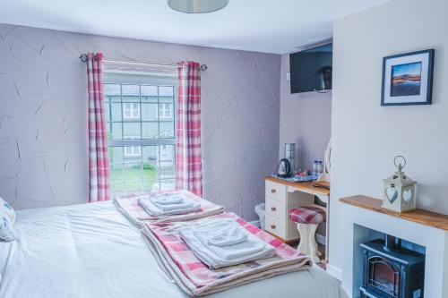 a bedroom with a bed and a window at The Cock Hotel in Bronllys