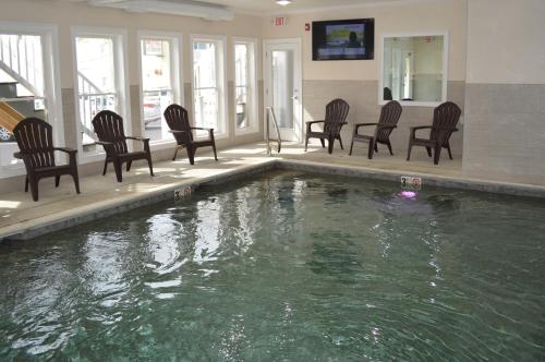 - un groupe de chaises et une piscine dans une maison dans l'établissement Copley LaReine Motel, à Old Orchard Beach