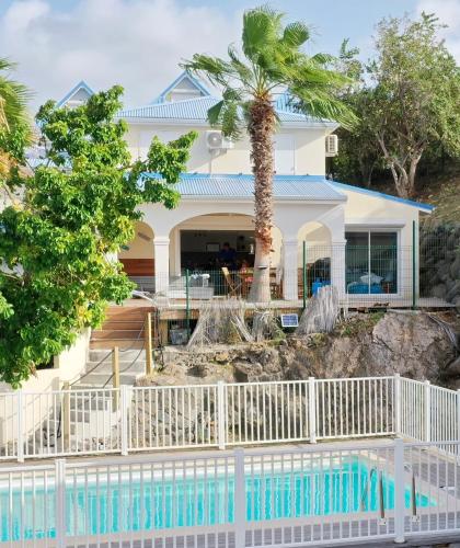 a house with a palm tree in front of it at Happy Friar's in Friar's Bay