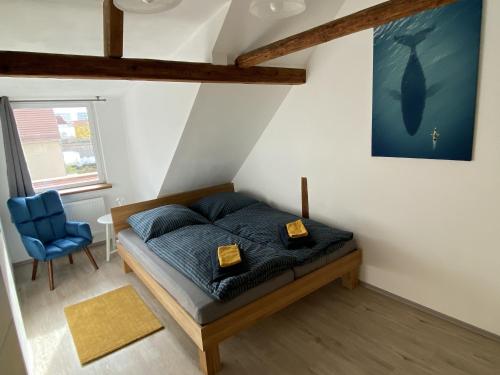 a bedroom with a bed and a blue chair at Ferienwohnung Happynest in Jena