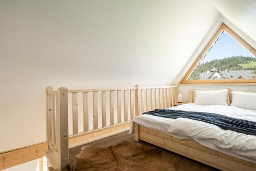 a bedroom with a bed and a large window at Zacny Lasek in Poronin