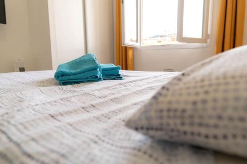 - un lit avec 2 serviettes assises au-dessus dans l'établissement NICE 3 CENTRE-VILLE STUDIO EN ETAGE REFAIT A NEUF, à Nice