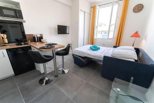 Cette chambre comprend un lit, une table et une cuisine. dans l'établissement NICE 3 CENTRE-VILLE STUDIO EN ETAGE REFAIT A NEUF, à Nice