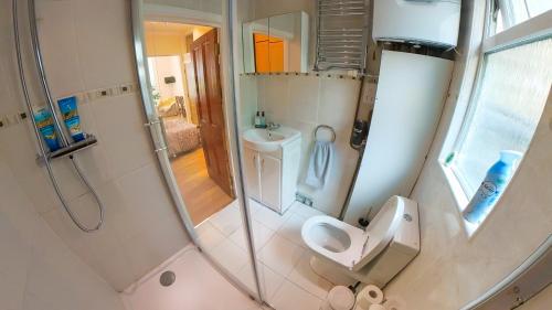a bathroom with a shower and a toilet and a sink at Lovely&Bright Studio Flat Close to Central London in London