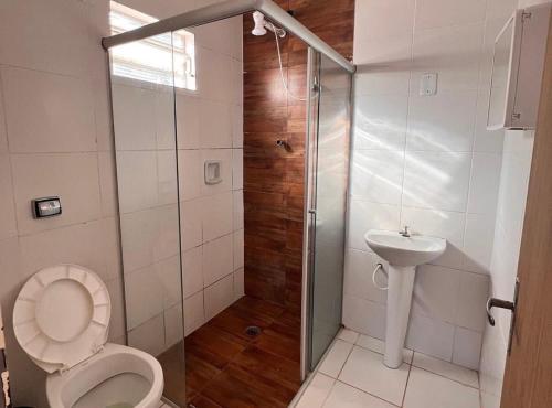 uma casa de banho com um chuveiro, um WC e um lavatório. em Sítio em Atibaia em Atibaia