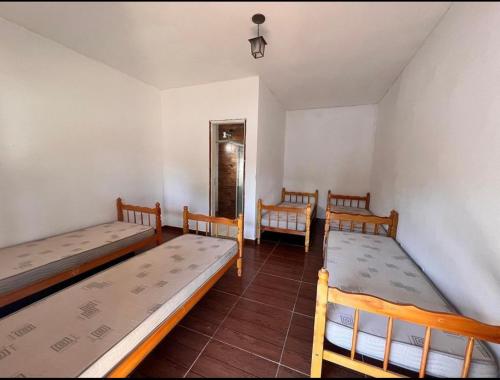 a room with three beds in a room at Sítio em Atibaia in Atibaia