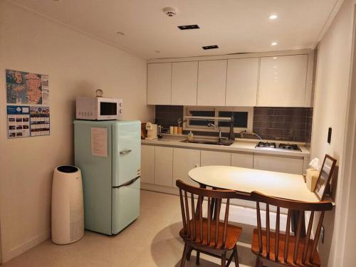 a kitchen with a refrigerator and a table with chairs at Blue moon stay in Incheon