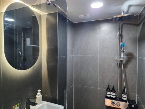 a bathroom with a shower and a sink and a mirror at Blue moon stay in Incheon