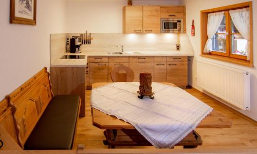 eine kleine Küche mit einem Tisch und einem Waschbecken in der Unterkunft Auf der Tannermühle in Bayrischzell