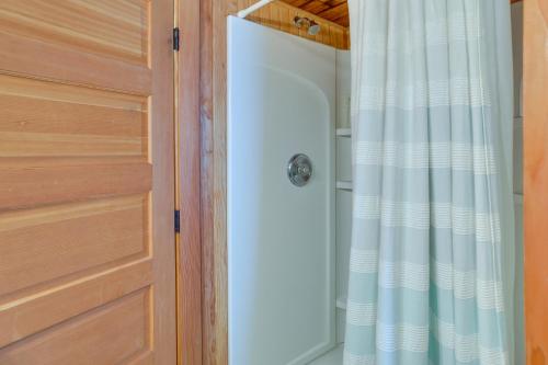 a shower with a white shower curtain next to a door at Historic Cottage w/ Beautiful Oceanfront View in Marshfield