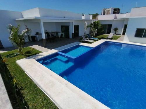 une grande piscine bleue en face d'une maison dans l'établissement V&G Las vacaciones que mereces, à Ursulo Galván