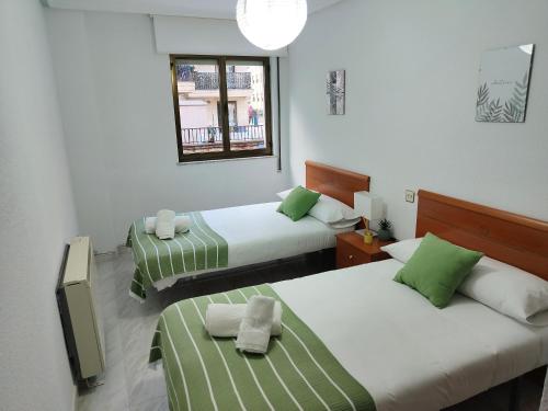 a bedroom with two beds with green and white sheets at Exclusiva vivienda en el centro de Salamanca in Salamanca