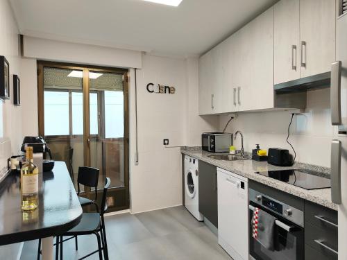 a kitchen with white cabinets and a table and chairs at Exclusiva vivienda en el centro de Salamanca in Salamanca