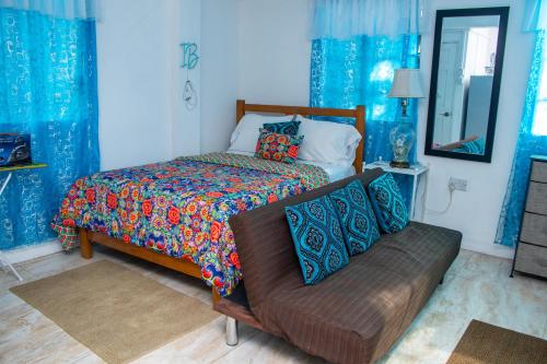 - une chambre avec un lit et un canapé dans l'établissement PRI Studio Apartment, à Arnos Vale