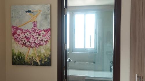 a bathroom with a painting and a glass shower door at Acogedoras vistas al illimani, cálido y accesible in La Paz