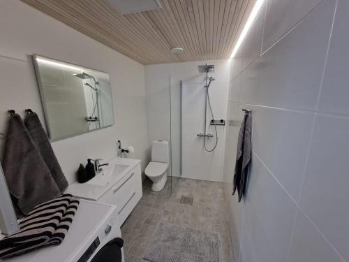 a white bathroom with a sink and a toilet at Cozzy apartment in old Rauma in Rauma
