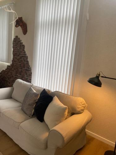 a white couch with pillows on it in front of a window at Cozzy apartment in old Rauma in Rauma