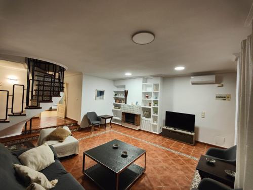 uma sala de estar com um sofá e uma televisão em Bungalow familiar con piscina em San Juan de Alicante
