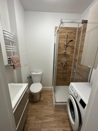 a bathroom with a shower and a toilet and a sink at Downtown Apartment Murano in Warsaw