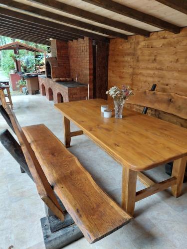 a wooden table and benches in a room at Misha's House in Porumbacu de Sus