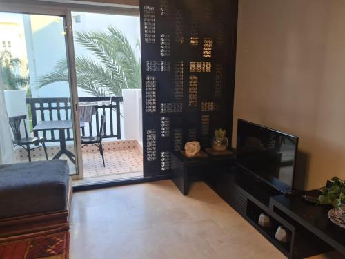 uma sala de estar com uma televisão e uma varanda em marinamarina em Agadir