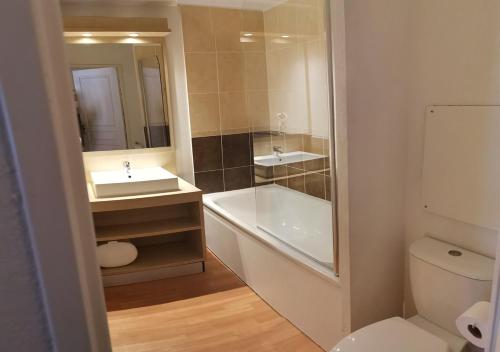 La salle de bains est pourvue d'une baignoire, d'un lavabo et de toilettes. dans l'établissement Superbe appartement en résidence avec piscine LES ORRES 1800, aux Orres