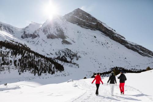 three people walking up a snow covered mountain at Seilers Vintage Hotel & Spa in Kandersteg