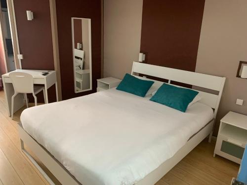 sypialnia z dużym białym łóżkiem z niebieskimi poduszkami w obiekcie Aix Hotel w Aix-en-Provence
