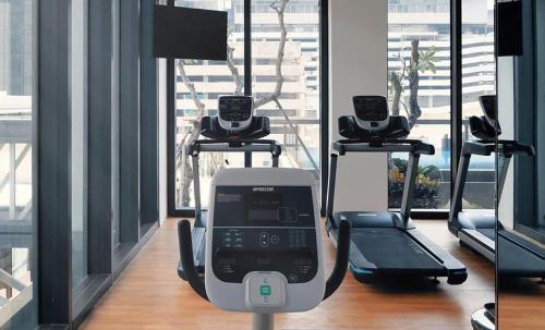 a gym with three treadying machines in a room at Mangkuluhur Residences by Lorin in Jakarta