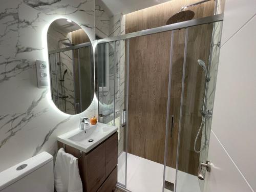 a bathroom with a sink and a shower with a mirror at Cozy apartment in Plaza España /Gran Vía in Madrid