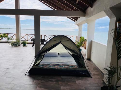 a tent on a patio with a view of the ocean at Merakai Hostel Rincon del Mar in Rincón