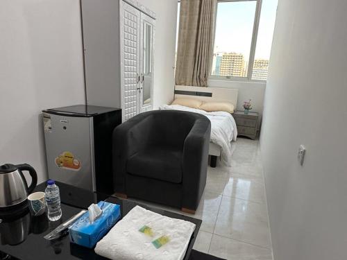 a living room with a chair and a bed at Corniche AD - Luxury Room in Abu Dhabi