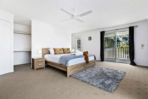 a bedroom with a bed and a ceiling fan at WhiteSands Beachouse in Urangan
