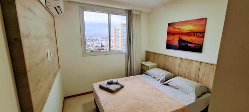 a small bedroom with a bed and a window at Top Wave Itapoã 2 (702s) in Vila Velha